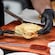 A chef preparing a serving of Francesinha, a Portuguese sandwich covered in melted cheese